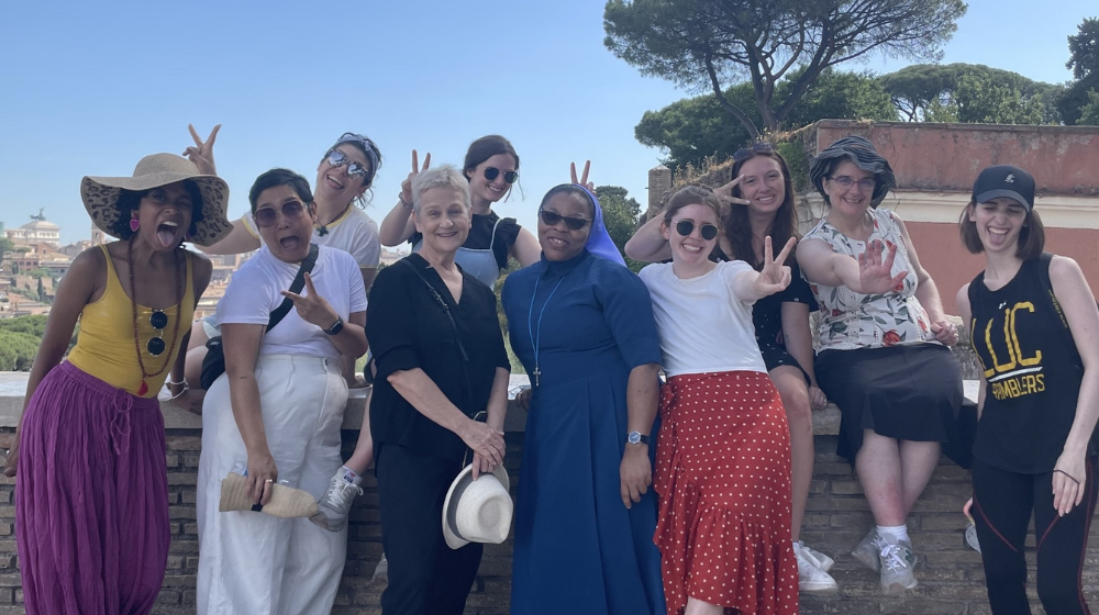 Loyola students walk down a sidewalk in Rome.